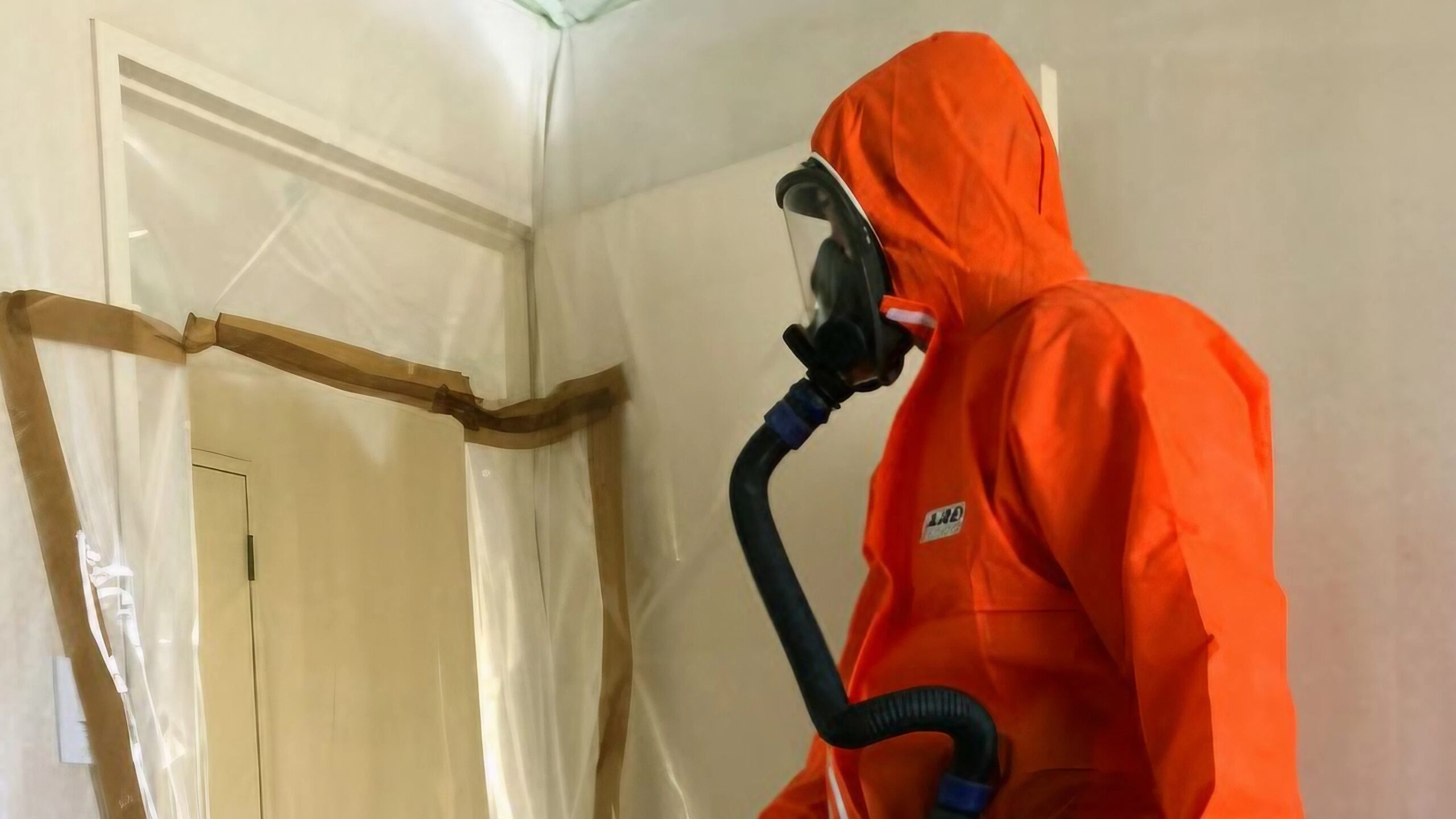 A man wearing a protective suit and breathing apparatus in a house